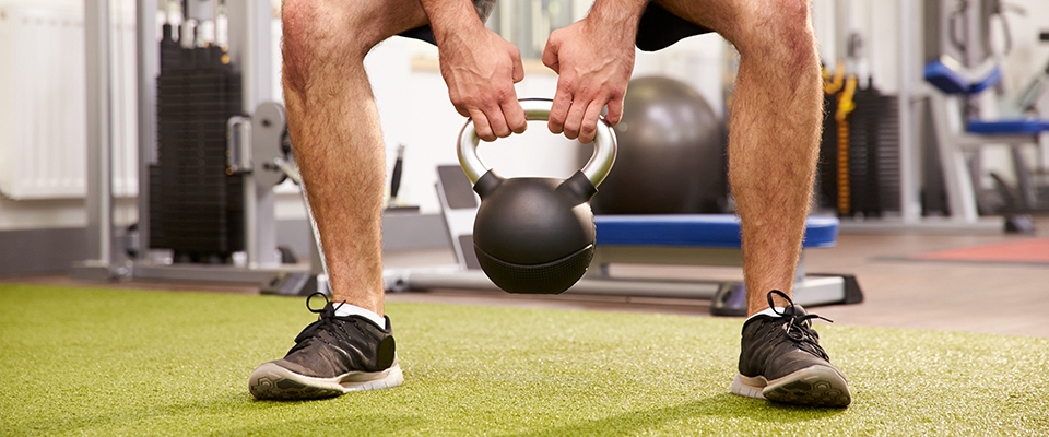 Homem a fazer exercício com kettlebell para perder peso | Holmes Place