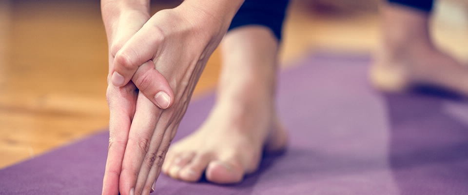 close-up mãos pés tapete yoga | Holmes Place