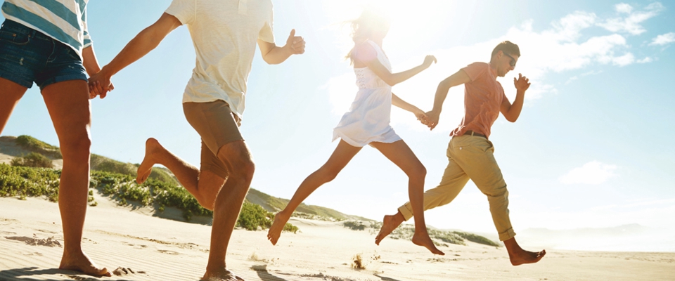 grupa osób biegnąca po plaży | Holmes Place