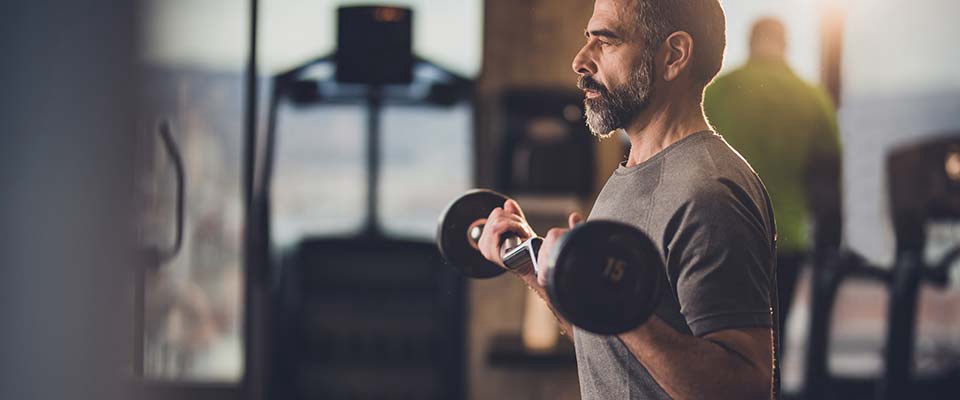 Homem a fazer bíceps | Fitness | Holmes Place