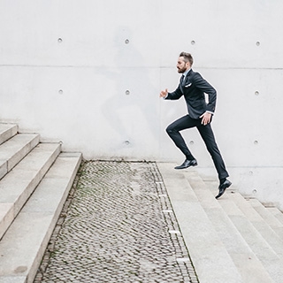 Holmes Place | Man in a Suit Climbing Stairs