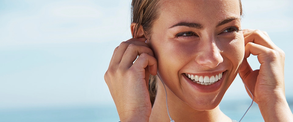 Holmes Place | Woman smiling and listening to music